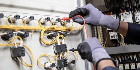 Electrician engineer tests electrical installations and wires on relay protection system....