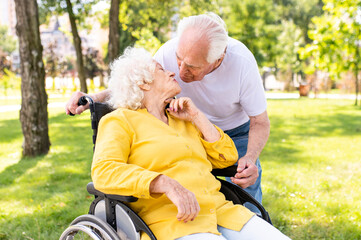 Senior married couple with disability having a romantic date outdoors
