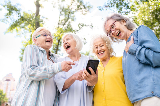 Group of seniors people bonding at the park - Beautiful old female friends using modern smartphone technology and social media app