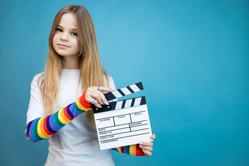 Young woman with movie clapperboard in her hands on a blue background