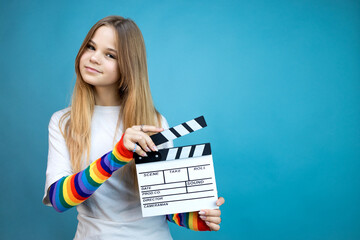 Young woman with movie clapperboard in her hands on a blue background