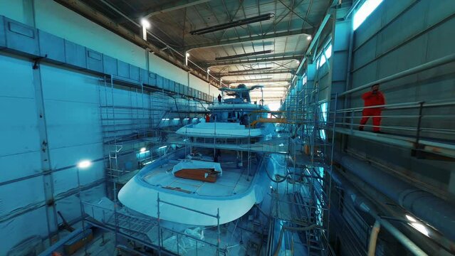 Luxury yacht construction under hangar in a shipyard. 4K. 1