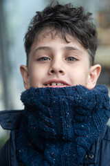 Portrait of a handsome boy with green eyes in a winter scarf