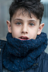 Portrait of a handsome boy with green eyes in a winter scarf