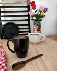 cup of coffee, spoon and flower on the table 
