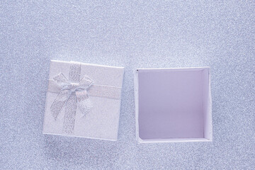 Silver open gift box on glitter silver background with copy space. Top view. Xmas, Valentines day...