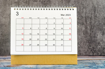 The March 2023 Monthly desk calendar for 2023 year on wooden table.