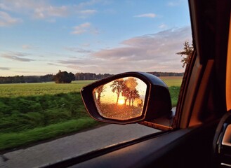 View of sunrise light in rear car mirror. Beautiful morning sunrise light reflection in rear car mirror