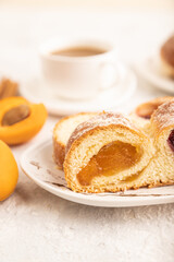 Homemade sweet bun with apricot jam on gray concrete. side view, selective focus.