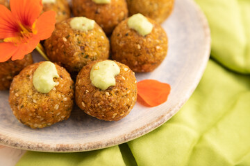 Falafel with guacamole on white concrete. Side view, selective focus.