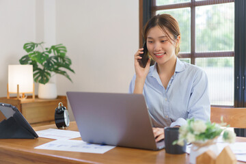 Business at home concept, Businesswoman talking with client on smartphone and typing data on laptop