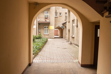 Alley between houses and yards in the old town on a cloudy day. Summer.