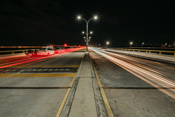 Headlights traces on the road bend in the night