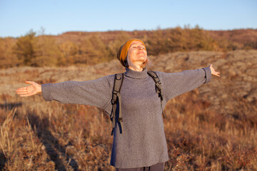 Middle aged woman hiking and going camping in autumn forest