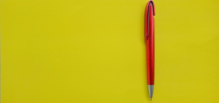 Ed Ballpoint Pen Or Red Pen In The Photo From Above On A Yellow Background