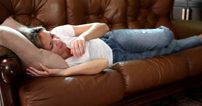 Young woman sleeping on sofa, sleeping attractive girl napping at home