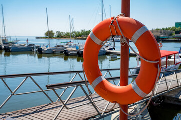 Orange lifebuoy hangs near swimming pool area