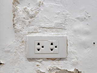 The power outlet on the cement wall that seeps with water causes the paint on the wall to peel and swell, causing the Leakage Current to be dangerous to people.