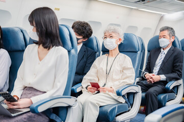 飛行機の機内で過ごす乗客