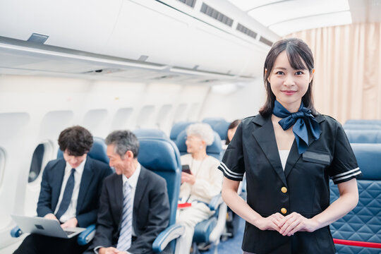 飛行機でお客様をご案内するキャビンアテンダント
