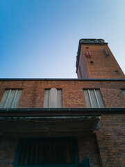 Looking up to wall and tower of old red brick church at sunny day