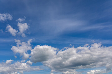 High summer sky with white cumulus clouds. Wind blows fluffy white clouds in blue sky