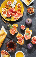 Appetizers board with traditional spanish tapas set. Italian antipasti bruschetta with prosciutto, cream cheese and fig
