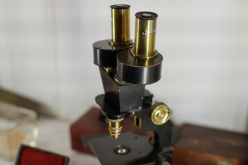 Shallow depth of field (selective focus) details with an old and used microscope inside a museum.