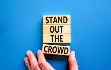 Stand out the crowd symbol. Concept words Stand out the crowd on wooden blocks on beautiful blue...