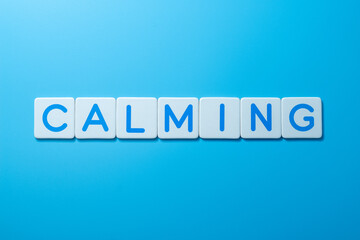 Word CALMING over a blue background,CALMING Concept