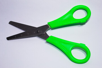 Metal scissors with green plastic parts
