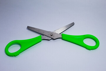 Metal scissors with green plastic parts