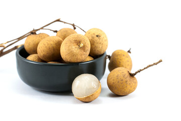 Sweet longan fruit in a black ceramic cup and placed on a white floor.