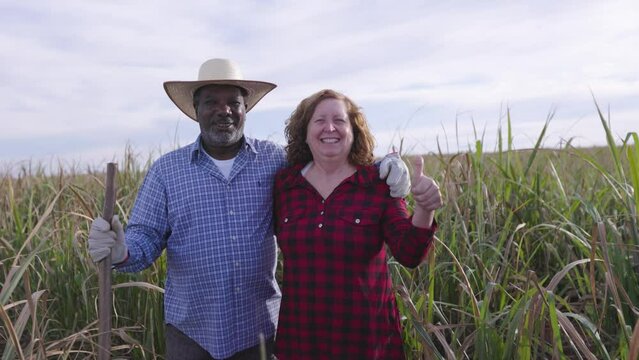 Brazilian Black farmer with his white wife on a sugar cane farm smiling and happy with life. Husband and wife of different ethnicities.