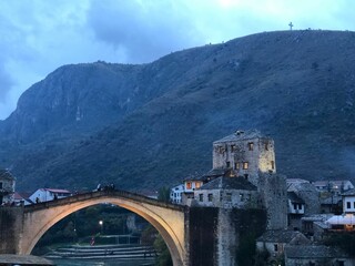 Beautiful shot of Mostar bridge with old buildings and mountain in Bosnia and Herzegovina