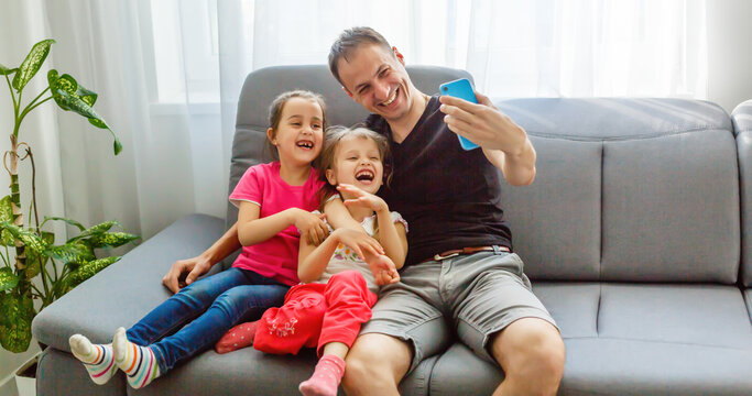 Young father with his cute little daughters taking selfie