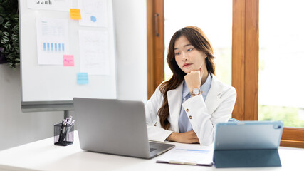 Businesswoman using laptop to work, Asian woman working in the office, Financial clerk or accountant with documents and equipment working on the desk, Using computers for financial transactions.