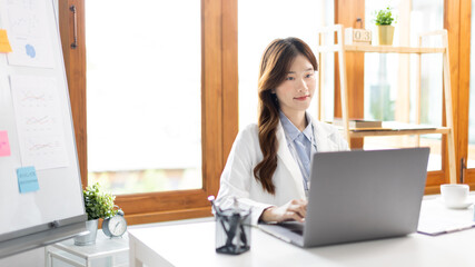 Businesswoman using laptop to work, Asian woman working in the office, Financial clerk or accountant with documents and equipment working on the desk, Using computers for financial transactions.