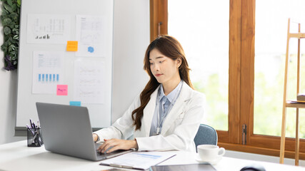 Businesswoman using laptop to work, Asian woman working in the office, Financial clerk or accountant with documents and equipment working on the desk, Using computers for financial transactions.