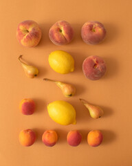 Neatly arranged fresh fruits on beige background. Minimal layout.