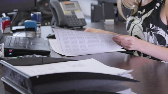 A business woman is given documents to sign. Hands of a woman signing a contract. Close-up