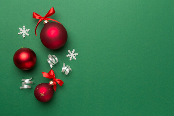 Christmas ball toys and confetti on color background, top view