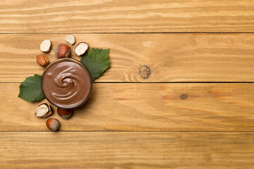 Hazelnuts cream with nuts on wooden background, top view