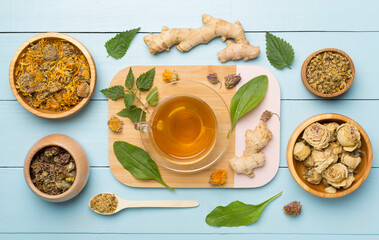 Herbal tea with ingredients on wooden background, top view