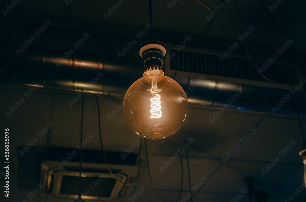 Wall mural Retro tungsten lightbulb in a coffe shop