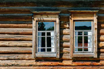 Fototapeta na wymiar Two windows in a wooden log house