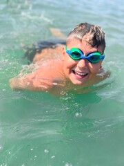 Naklejka premium Caucasian boy wear scuba mask swim in the sea close portrait with wide big smile