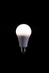 Burning LED eco friendly light bulb on black background.