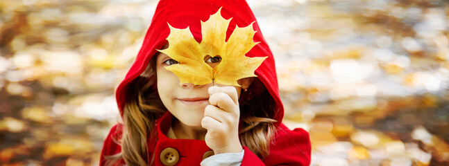 child in a red coat with autumn leaves. Love autumn. Selective focus.