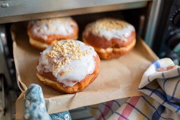 a woman cook takes out sweet Polish donuts from the oven